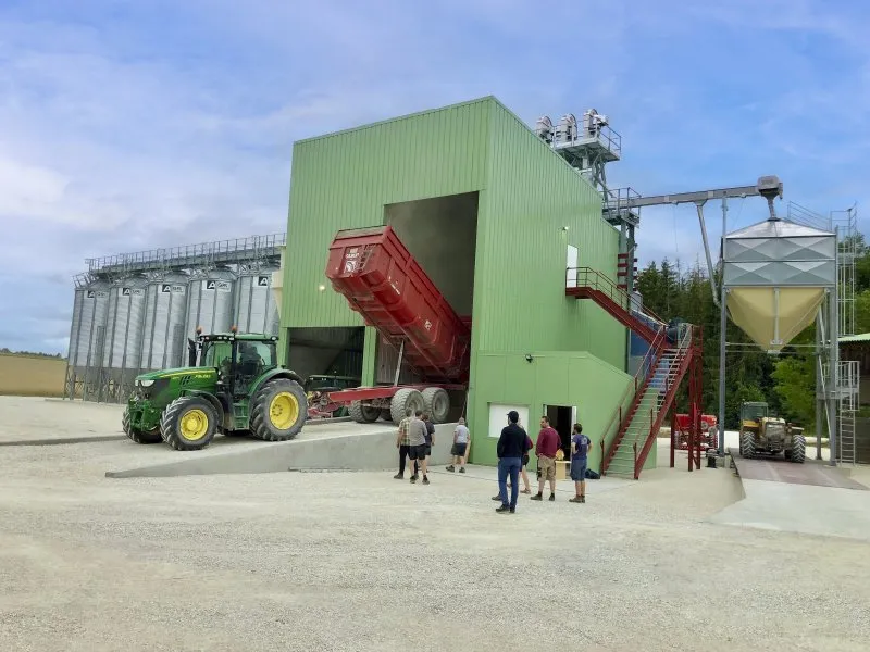 installation clé en main Agriconsult ciel bleu extérieur bâtiment photovoltaïque tracteur John Deere déchargement benne boisseau céréales grains silos cellules fond conique
